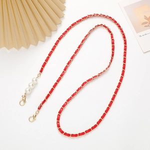 Detail of red leather woven chain strap with gold lobster clasps and white faux pearls