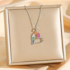 Collier cœur ajouré avec zircons arc-en-ciel sur une boîte à bijoux dorée