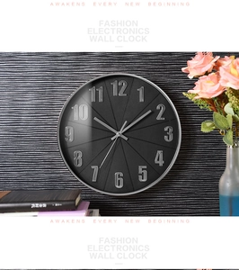Detail of wall clock featuring a black dial with 3D numbers and silver metal frame