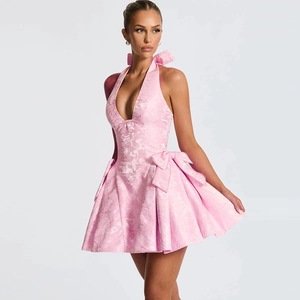 Detail of pink floral jacquard fabric and large bow on sleeveless halter neck dress