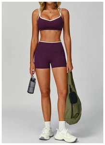 Close-up of contrast purple sports bra and high-waist shorts with gym bag and water bottle