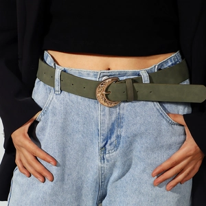 Army green vintage belt with gold floral horseshoe buckle on light blue denim jeans