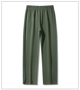 Detailed view of elastic waistband and textured fabric on dark green casual straight pants