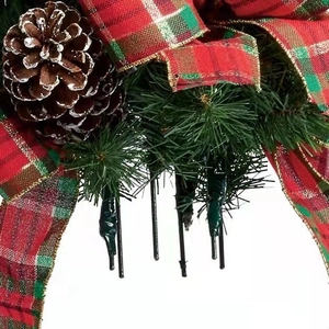 Christmas tree decoration with realistic pine needles, snowy cone and plaid ribbon bow