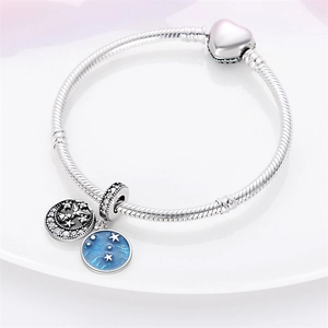 Detail of silver heart clasp bracelet with blue enamel star and moon charms