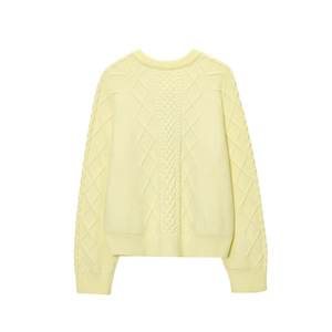 Pale yellow cable knit sweater with diamond mesh texture and ribbed trim in flat lay view