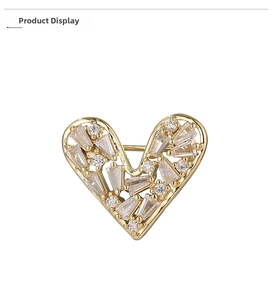 Macro detail of gold heart brooch with marquise and round cut inlaid cubic zirconia
