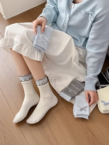 Détail de chaussettes en tricot avec nœud et bord à volants aux couleurs pastel