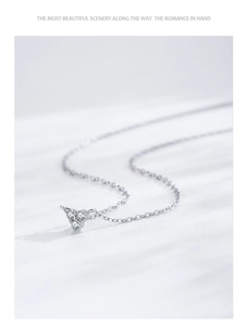 Macro shot of silver S925 geometric triangle pendant necklace with three sparkling zircons