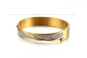 Detail of 12mm gold stainless steel wide bangle with zircon inlay and brushed finish