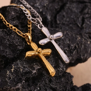 Macro shot of polished gold and silver cross pendants on a textured black mineral background