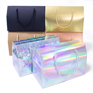 Assorted gift boxes in matte black, gold, and holographic finishes with rope handles