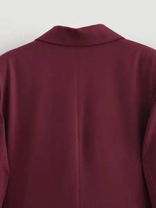 Dettaglio del colletto posteriore e delle cuciture della spalla di un blazer bordeaux