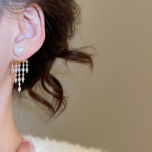 Close-up of 14K gold plated pearl earrings with marquise zircon tassels on a model