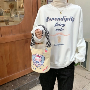 Nahaufnahme der Canvas-Beuteltasche mit Hasenprint und kariertem Griff auf Holzgrund