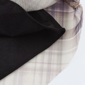 Detailaufnahme von lila kariertem Netzstoff und schwarzem elastischem Stricksaum