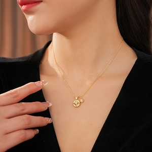 Gros plan d'un collier doré avec deux pendentifs circulaires sertis de zircons brillants