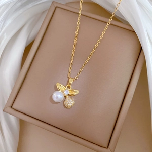 Macro view of gold pendant with white pearl and pave crystals in jewelry box