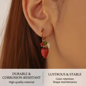 Close-up of a 3D strawberry pendant earring on a golden hoop with vibrant bead details