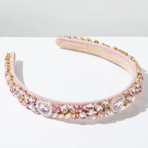 Detail van roze fluwelen barokke haarband met fonkelende kristallen en hartjes