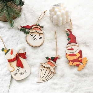 Wooden Christmas hanging ornaments with Santa and Snowman figures on white snow scenery