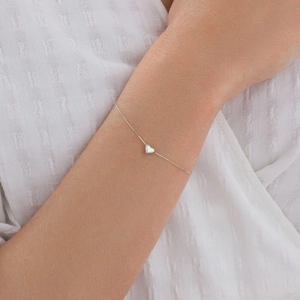 Close-up of minimalist 925 sterling silver heart charm bracelet on female wrist