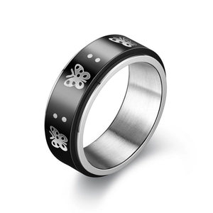 Detail of rotating anxiety ring with black butterfly pattern and brushed silver inner band