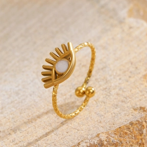 Detailed view of sunburst gold ring with central white stone and hammered metal texture