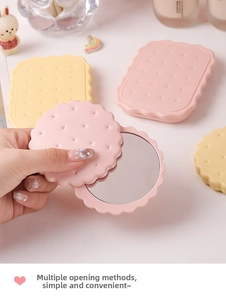 Detail view of cookie-shaped portable makeup mirrors in pink and yellow pastel colors