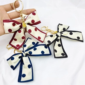 Detail of bohemian silk bow wristlet keychains in red, black, and blue polka dots