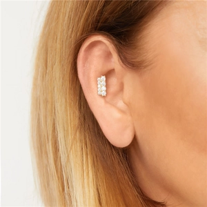 Close-up of a gold S925 silver tragus stud earring with shimmering pavé set diamonds