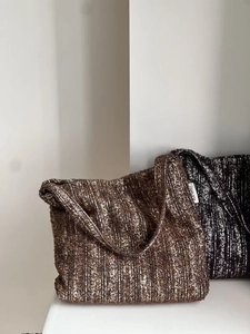Detailed texture of thick knit tote bags with simple wish label in a minimalist setting