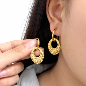 Golden stainless steel hoop earrings with hammered texture and sunburst detail