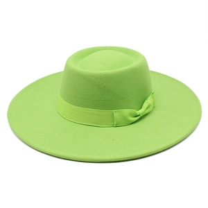 Détail d'un chapeau en laine verte avec ruban de soie assorti et nœud sur la couronne