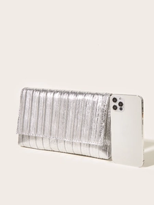 Pochette da sera argentata plissettata accanto a uno smartphone per scala dimensionale