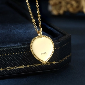 Close-up of S925 sterling silver heart-shaped gold pendant with beaded edge details