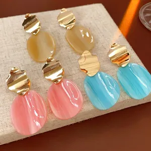 Irregular acrylic oval drop earrings with golden wavy studs in three vibrant colors