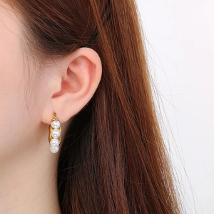 18k gold C-shape stainless steel earrings with three shell pearls on a female model