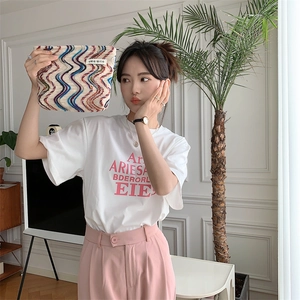 Close-up of rainbow wavy knit texture and logo label on the canvas cosmetic bag