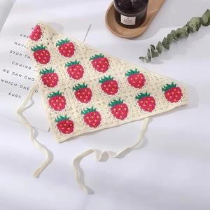 Detail of crochet strawberry headscarf with handmade floral knit patterns and ties