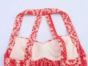 Detail van rood bloemenborduurwerk op gebroken witte midi-jurk met elastiek in de taille