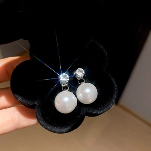 Close-up of vintage pearl earrings with zircon inlay in a black jewelry box