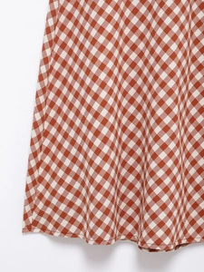Close-up of red and white gingham fabric texture and stitching for two-piece set