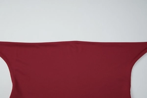 Close-up of wine red knit top featuring elegant low-cut neckline and fringe detail