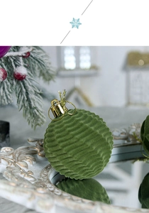 Close-up of green flocked Christmas ball with wavy texture and gold loop ornament