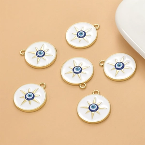 Detail of white enamel evil eye star charms with golden frames for jewelry making