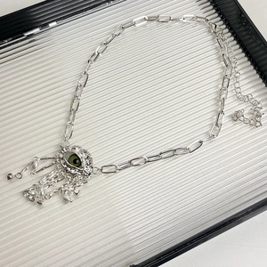 Detailed shot of evil eye pendant with silver tassel and white pearls on texture