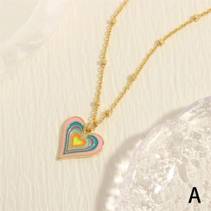 Minimalist gold chain necklace with a colorful rainbow heart pendant in gradient enamel