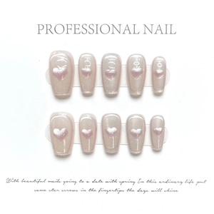 Detail of short almond press-on nails with pearl luster and pink heart cat-eye design