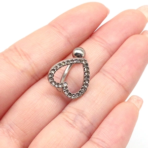 Macro shot of silver heart belly button ring with sparkling rhinestones on white background